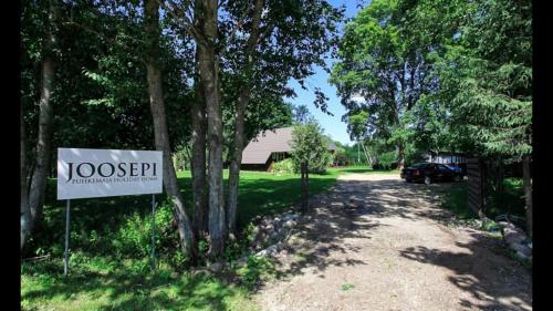 a sign in front of a driveway with a house at Joosepi Holiday House in Silla