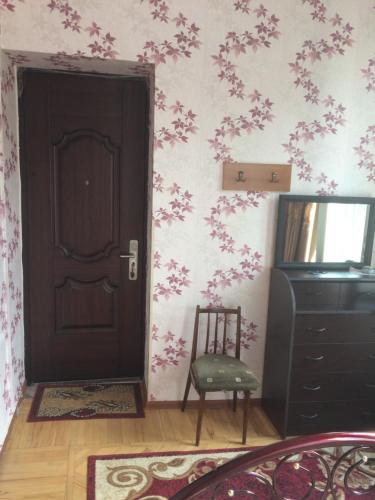 a room with a black door and a chair at Giorgi's Homestay in Kutaisi
