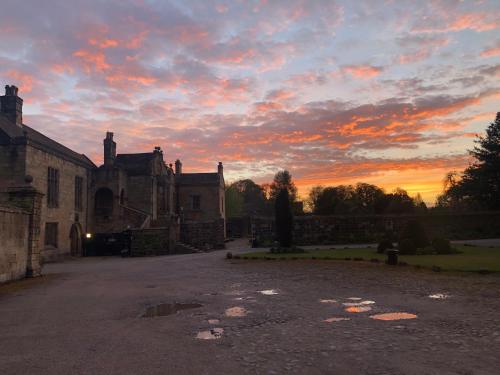 un edificio antiguo con una puesta de sol en el fondo en Whalley Abbey - Christian Retreat House offering B&B, en Whalley