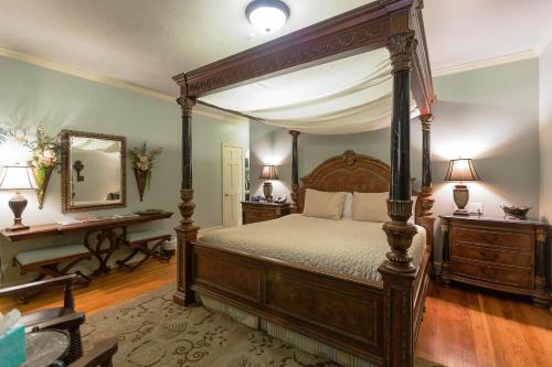 a bedroom with a canopy bed and two tables at The Campbell Hotel in Tulsa