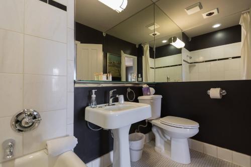a bathroom with a sink and a toilet and a mirror at The Campbell Hotel in Tulsa