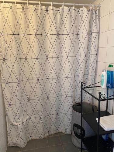 a shower curtain in a bathroom with a tile wall at Helsingborgs Vandrarhem, Helsingborg Hostel in Helsingborg