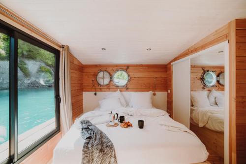 1 dormitorio con cama y ventana grande en Les Toues Cabanées du lac, en Le Sauze-du-Lac