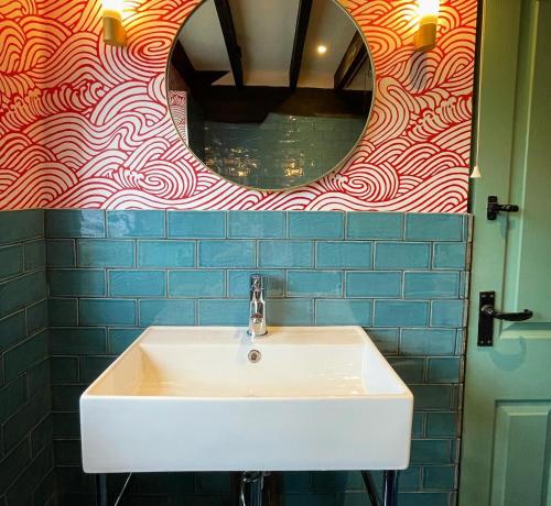 a bathroom with a white sink and a mirror at Sculthorpe Mill in Fakenham