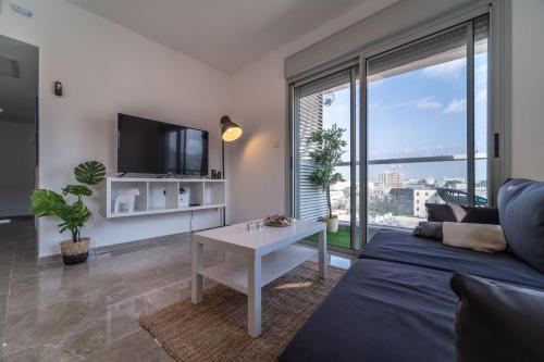 sala de estar con sofá y mesa en PORT CITY HAIFA - German Colony Luxurious 2 bdrms Apt, en Haifa