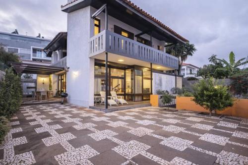 a house with a large patio in front of it at Charming Villa, spacious, beautiful views! in Funchal