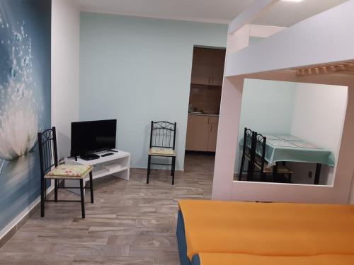 een woonkamer met een tv en een bank en stoelen bij GRÉTA APARTMAN A BALATONNÁL,CSOPAKON!!! in Csopak