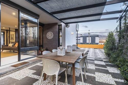 an outdoor dining room with a wooden table and chairs at Charming Villa, spacious, beautiful views! in Funchal