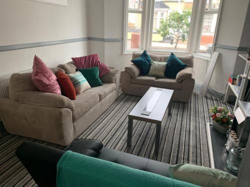 a living room with two couches and a coffee table at Blackpool Abode - Seaside Cove in Blackpool