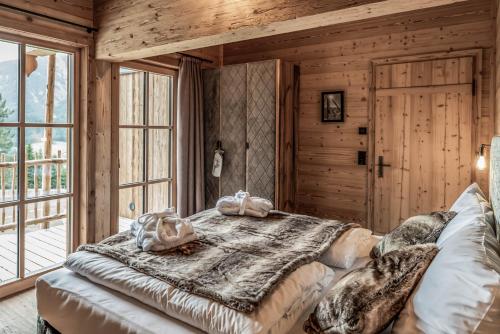 a bedroom with a large bed in a log cabin at Benglerwald Berg Chaletdorf in Bach