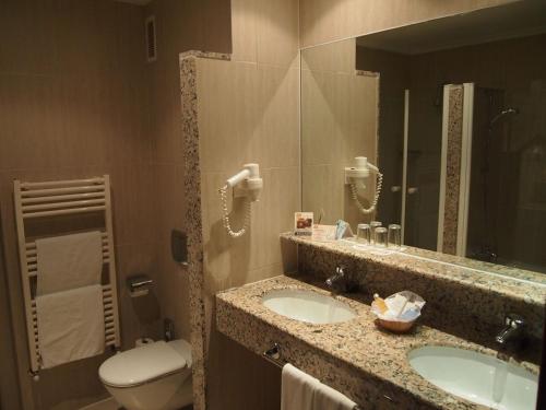 een badkamer met 2 wastafels, een toilet en een spiegel bij Bordoy Don Antonio in Paguera