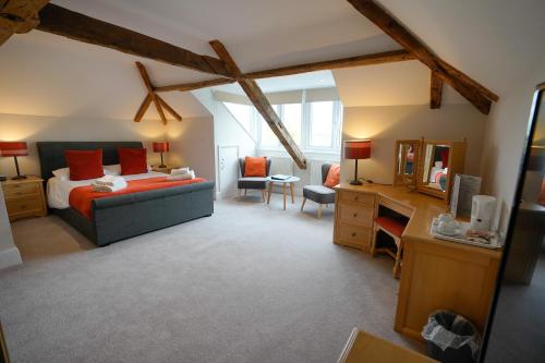 1 dormitorio con cama y escritorio en Waveney House Hotel, en Beccles