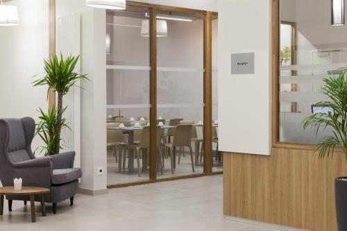 a dining room with a table and a chair and a table at Nehô Suites Porte de Genève - Gare Annemasse in Annemasse