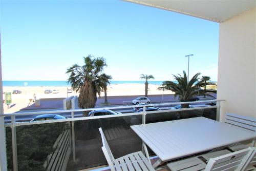 - un balcon avec une table et des chaises et la plage dans l'établissement Studio vue mer, à Canet