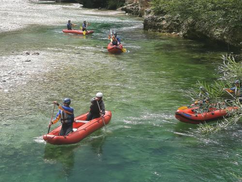 a group of people in kayaks on a river at Snežak (Snowman) 2 in Bohinj