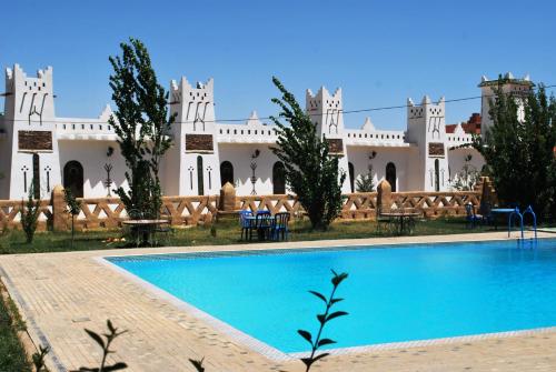 un complejo con piscina frente a un edificio en Ksar Timnay Hotel en Aguelmous