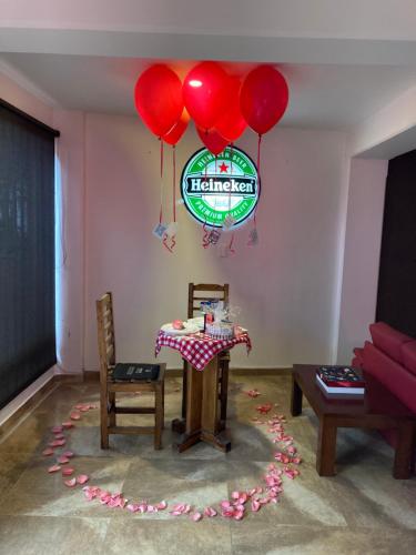 a living room with a table and red balloons at Camino A La Villa Cucaita Hotel in Cucaita