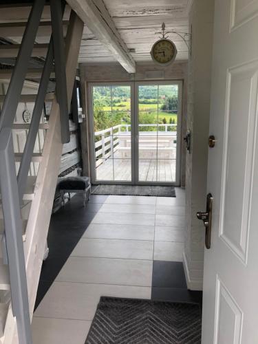 a hallway with a door and a clock on the wall at Koperkowy Raj Beskid Wyspowy Domek Małopolska Jacuzzi Playroom in Laskowa