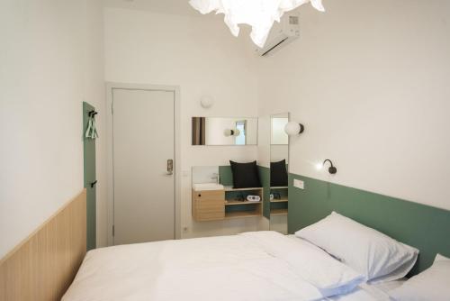 a small bedroom with a bed and a mirror at CAPSULE HOTEL & HOSTEL in Kharkiv