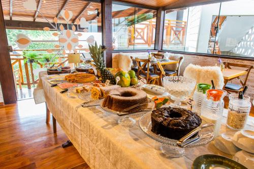 a long table with bread and other food on it at Hotel Harmonia Monte Verde in Monte Verde