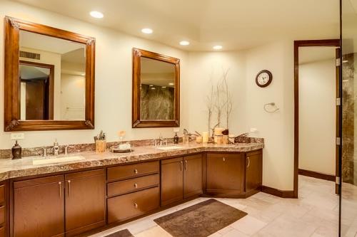 un baño con dos lavabos y dos espejos en Escape to Luxury at PGA West Permit# 67092, en La Quinta