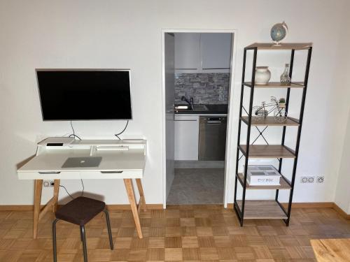 a living room with a desk and a television at Private Wohnung in Fürstenfeldbruck, nahe Ammersee/München/Augsburg in Fürstenfeldbruck