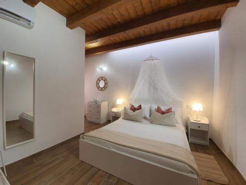 1 dormitorio blanco con 1 cama grande y espejo en Casa Ludo - Fondi Vertice Rooms, en Fondi