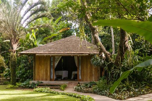 a small house with a tree in front of it at Pousada Capim Santo in Trancoso