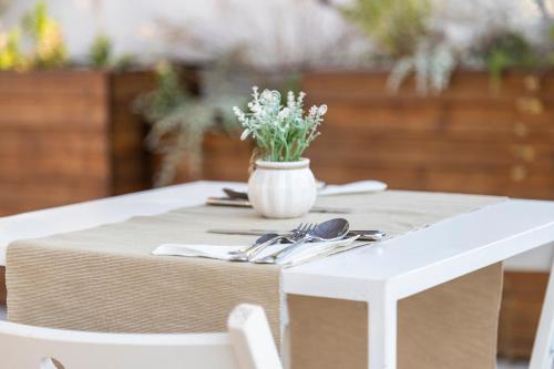 a white table with a vase of flowers on it at Marla's boutique rooms in Noto