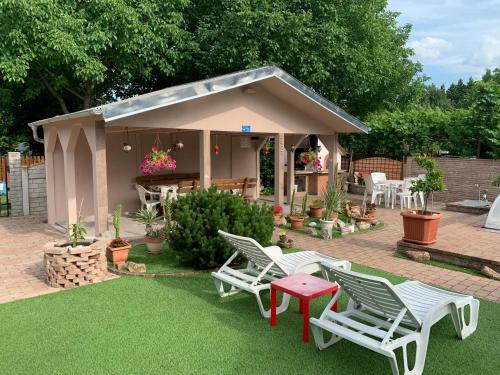 a backyard with chairs and a table and a house at Mediterán Fedett Medencés Apartmanház in Szántód