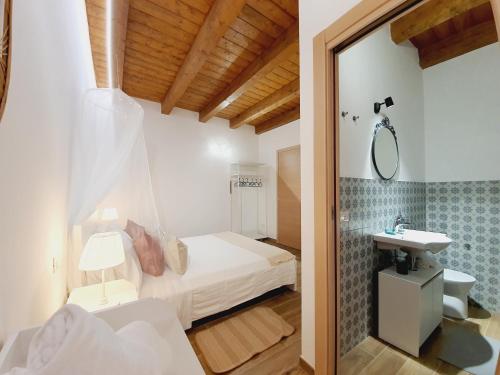 1 dormitorio con cama, lavabo y espejo en Casa Ludo - Fondi Vertice Rooms, en Fondi