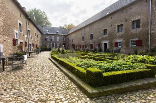 a courtyard with a garden of plants and buildings at Meschermolen 9 in Mesch