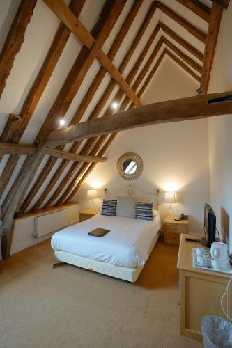 a bedroom with a white bed in a attic at Waveney House Hotel in Beccles