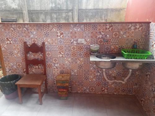 a small bathroom with a sink and a chair at Chalé das Flores in Tiradentes
