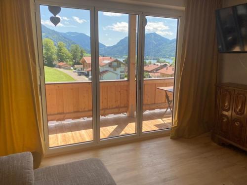 a room with a large window with a view of the mountains at Apartment Schlierseeblick - ruhig mit tollem See- und Bergblick in Schliersee