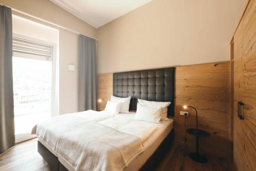 ein Schlafzimmer mit großem Bett und Fenster in der Unterkunft REMIND Apartements Brixental in Brixen im Thale