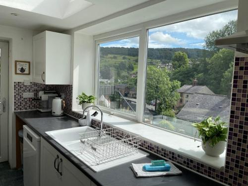 a kitchen with a sink and a large window at Roseville in Matlock