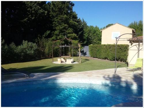 - une piscine dans une cour avec un kiosque dans l'établissement Clos St Pierre de Fraisse, à Montfavet