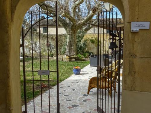 ein Tor zu einem Garten mit einem Baum dahinter in der Unterkunft Clos St Pierre de Fraisse in Montfavet