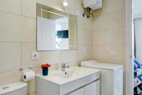 a bathroom with a sink and a toilet and a mirror at Albamar 1a in Puerto de Mogán