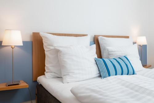 a white bed with a white comforter and pillows at Hotel Petit Skagen, Sure Hotel Collection by Best Western in Skagen
