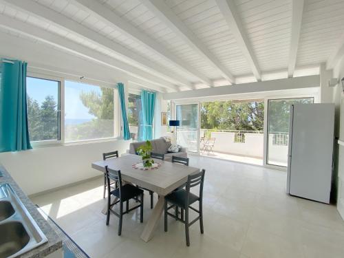 a kitchen and dining room with a table and chairs at Attico vista mare in villa antica in Torre Pali 