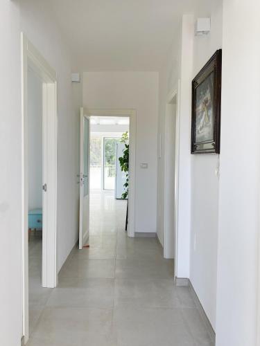 an empty hallway with white walls and a painting on the wall at Attico vista mare in villa antica in Torre Pali 