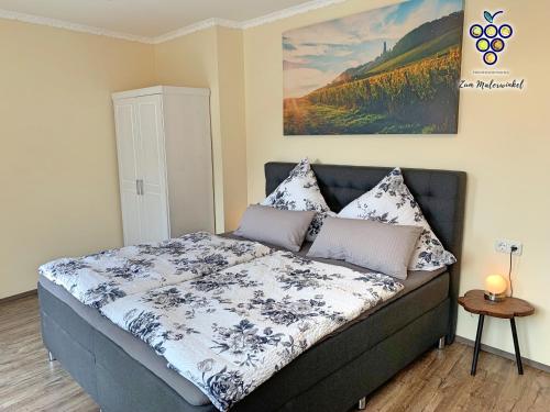 a bedroom with a bed with a blue and white comforter at Fewo Zum Malerwinkel - Rüdesheim in Rüdesheim am Rhein