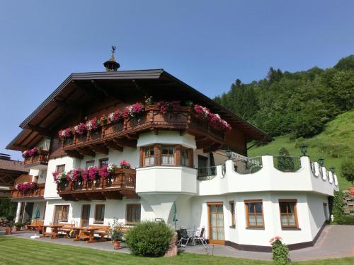 ein Gebäude mit einem Balkon mit Blumen darauf in der Unterkunft Landhaus Gruber Winter in Alpendorf