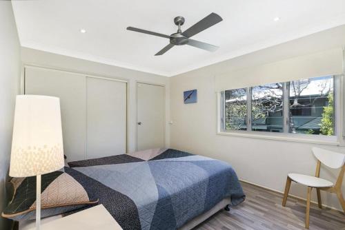 a bedroom with a bed and a ceiling fan at Moreton View in Point Lookout
