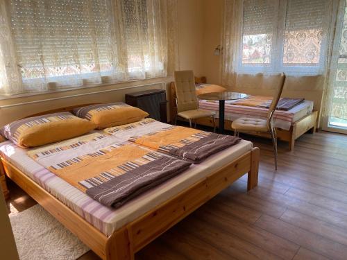 - une chambre avec un lit, une table et des chaises dans l'établissement Erdei vendégház, à Hajdúszoboszló