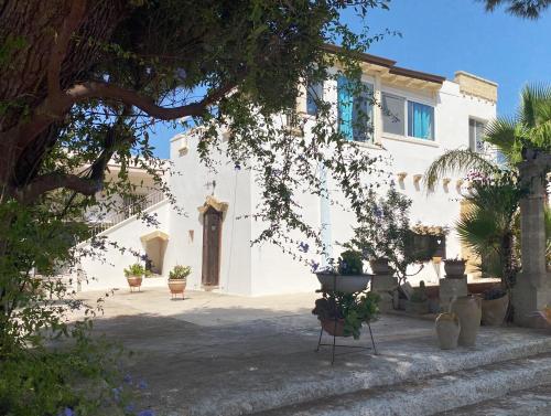 a white house with potted plants in front of it at Attico vista mare in villa antica in Torre Pali 