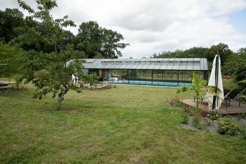 a garden with a swimming pool and a building at Chateau L' Escale in Saint-Herblon