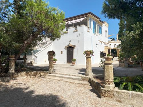 a white church with a door and trees at Attico vista mare in villa antica in Torre Pali 